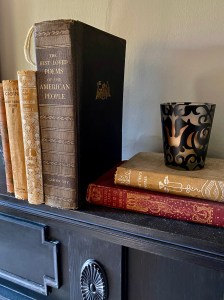 antique books on a fireplace mantel